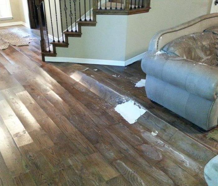 Laminate wood flooring buckled in living with stairs and furniture